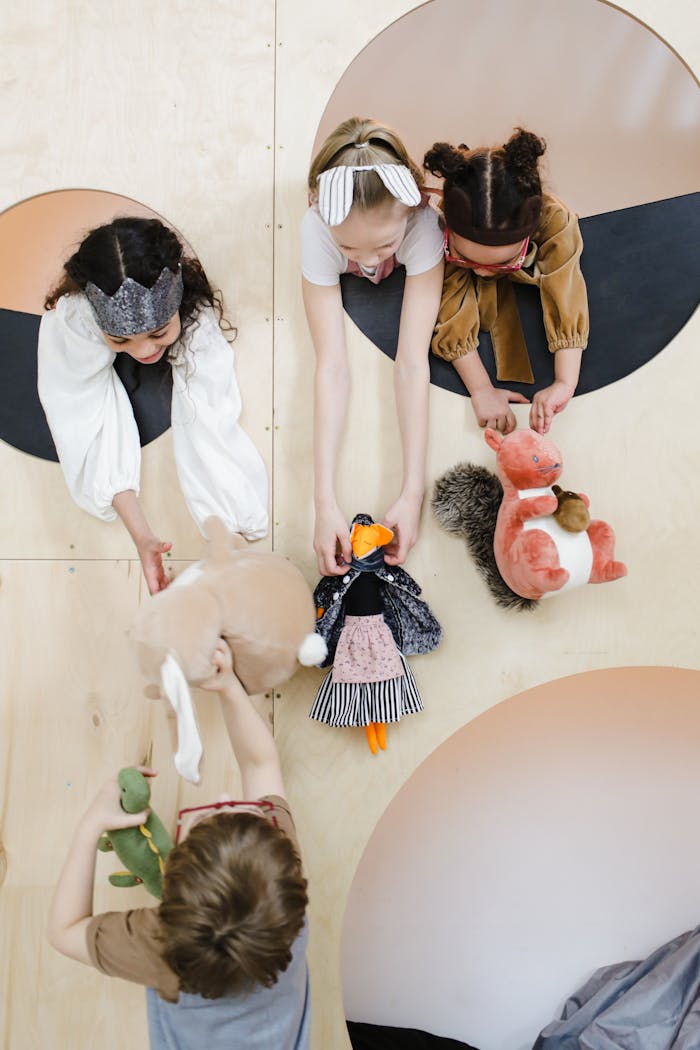 Top view of diverse kids playing together with toys on a colorful patterned surface.